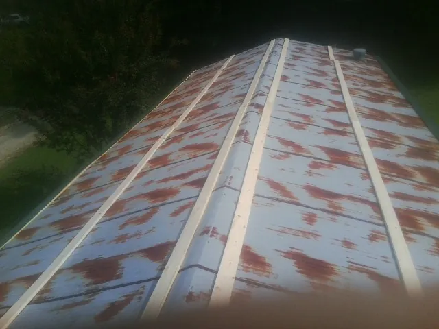 Rusted metal roof panels with new wood purlins before replacement — Storm Damage Roof Repair in Toquerville by Roofing Brothers