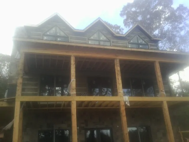 Dormers and porch framing on a large log home under construction — Roof Coating work by our crew in Toquerville